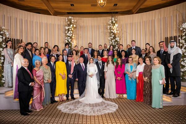 A handout picture released by Jordan's Royal Palace shows King Abdullah II (7th L) and Queen Rania (6th R) posing for a picture with members of the Jordanian royal family and the bride and groom, during the wedding ceremony of their eldest daughter Princess Iman and Jameel Alexander Thermiotis (C) in Amman on March 12, 2023.
