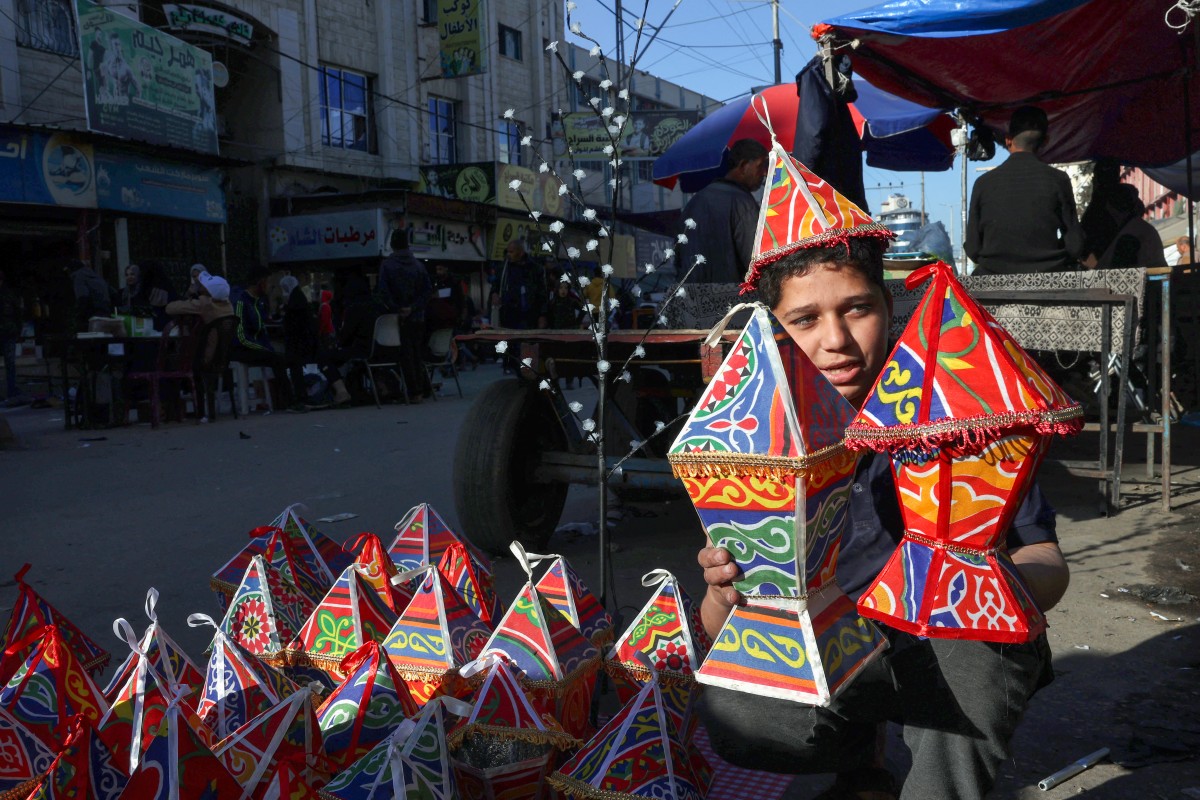 A Palestinian street vendor sells traditional "fanous" lanterns as Muslim devotees prepare for the start of the holy fasting month of Ramadan, in Rafah town in the southern Gaza Strip on March 5, 2024, amid ongoing battles between Israel and the militant group Hamas. (Photo by SAID KHATIB / AFP)