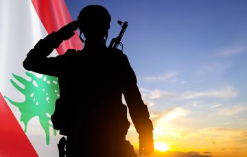 جندي من الجيش اللبناني يؤدي التحية العسكرية أمام العلم اللبناني
