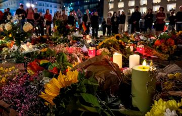 Candles are lit among flowers in commemoration of the victims of the attack.