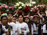 Buddhist devotees carry water and flowers during Buddha's birthday in Mandalay, on May 18, 2019. Buddhists commemorate the birth of Buddha, his attaining enlightenment and death on the day of the full moon, which falls on May 18 this year. YE AUNG THU / AFP