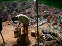 This photo taken on May 16, 2019 shows miners collecting earth containing rubies and other gemstones in a ruby mine in Mogok, north of Mandalay. Burrowing deep underground, thousands of informal miners risk their lives to find gleaming red gems as a law change spurs opportunity in Myanmar's "land of rubies". Ye Aung THU / AFP