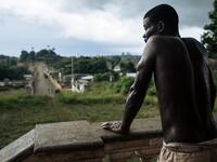 An inhabitant waits in front of the abandoned hospital of the roca Agostinho Neto, an abandoned cocoa plantation of Sao Tome and Principe, on May 12, 2019.  Alexis HUGUET / AFP