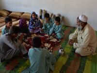 In this photograph taken on May 3, 2019, Afghan man Hamisha Gul 65, looks as his disabled children eat breakfast in their house in the Khogyani district of Nangarhar province. NOORULLAH SHIRZADA / AFP