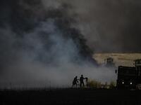 People battle a blaze next to an oil well in an agricultural field in the town of al-Qahtaniyah, in the Hasakeh province near the Syrian-Turkish border on June 10, 2019. Fires have erupted in various parts of Syria in recent weeks, with all sides blaming each other for starting them. Delil souleiman / AFP