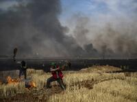 People battle a blaze in an agricultural field in the town of al-Qahtaniyah, in the Hasakeh province near the Syrian-Turkish border on June 10, 2019. Fires have erupted in various parts of Syria in recent weeks, with all sides blaming each other for starting them. Delil souleiman / AFP