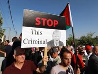 A protester holds an anti-Donald Trump sign as he marches with others during the "March of Anger" demonstration leading to the US Embassy in the Jordanian capital Amman on  June 21, 2019, against US President Donald Trump's "Deal of the Century"  and the US-led Middle East economic conference in Bahrain.   Khalil MAZRAAWI / AFP