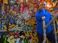 This picture taken on March 30, 2019 shows Hakka graffiti artist Wu Tsun-hsien posing for photos at his home in the Taiwanese village of Ruan Chiao. Nestled in the mist-covered foothills of Taiwan's central mountain range, Ruan Chiao village is virtually devoid of young people, but artist Wu Tsun-hsien is coaxing the Instagram generation back by transforming local homes into a canvas of colour. Sam YEH / AFP