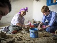 Moroccan potter Aicha Tabiz (L), also known as Mama Aicha, sits next to British apprentice Kim West (R), 33, during a pottery workshop near the village of Ourtzagh in the foothills of the Rif mountains on June 12, 2019. FADEL SENNA / AFP