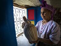 Moroccan potter Aicha Tabiz, also known as Mama Aicha, holds one of her works near the village of Ourtzagh in the foothills of the Rif mountains on June 12, 2019. Like everywhere in the Rif mountains, women potters from the Sless tribe, to which Aicha Tabiz's family belongs, are vanishing.  The tribe counted around 90 potters at the end of 1990s. Now, only a half-dozen remain.   FADEL SENNA / AFP