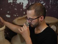 Palestinian distiller Nader Muaddi smells a glass of his Arak in the West Bank village of Beit Jala, near Bethlehem, on June 16, 2019. In his basement, distiller Muaddi made fewer than 500 bottles of liquor last year, but it is earning global acclaim and reviving interest in the Palestinian alcohol sector. On the outskirts of the city famed for Jesus's birth, the 35-year-old illustrates the handcrafted way he makes Arak, an anise-flavoured drink popular in the Middle East and similar to Greek Ouzo, French P