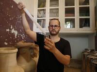 Palestinian distiller Nader Muaddi uses an alcoholometer to measure the amount of alcohol in his Arak in the West Bank village of Beit Jala, near Bethlehem, on June 16, 2019. In his basement, distiller Muaddi made fewer than 500 bottles of liquor last year, but it is earning global acclaim and reviving interest in the Palestinian alcohol sector. On the outskirts of the city famed for Jesus's birth, the 35-year-old illustrates the handcrafted way he makes Arak, an anise-flavoured drink popular in the Middle 