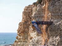 A cliff diver jumps from a platform on the landmark Raouche sea rock off the coast of the Lebanese capital Beirut on July 14, 2019, during the men's 2019 Red Bull Cliff Diving World Series.  ANWAR AMRO / AA / AFP
