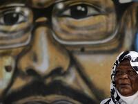 Maiyssa Omar, the mother of Walid Abdelrahim sits in front of the mural painting of her son, ornating the family home in the Sudanese capital Khartoum on July 21, 2019.  ASHRAF SHAZLY / AFP