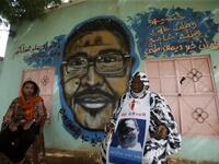 Maiyssa Omar (R), the mother of Walid Abdelrahim and Sudanese artist Assil Diab, sit in front of the mural painting of Abdelrahim ornating the family home in the capital Khartoum on July 21, 2019.  ASHRAF SHAZLY / AFP