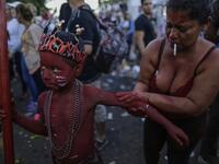 A catholic faithful woman paints her son with floor painture during the opening of the ten-day celebration of the Santo Domingo de Guzman festival in Managua, on August 1, 2019.  INTI OCON / AFP