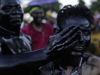 Catholic faithful smeared in burnt oil, take part in the opening of the ten-day celebration of the Santo Domingo de Guzman festival in Managua, on August 1, 2019.  INTI OCON / AFP