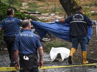 Turkish police officers cover a body on the ground in Eminonu district, Istanbul, after a heavy rainfall, on August 17, 2019. Turkey's mega city Istanbul was lashed by a heavy rainstorm on August 17, killing a homeless man and leaving parts of the historic Grand Bazaar flooded.  Ozan KOSE / AFP