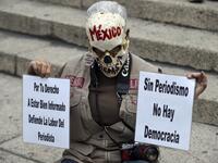 In this file photo taken on March 25, 2017 Mexican activist Julia Klug holds signs reading "For your right to be well informed, defend the journalist's work" and "Without journalism there is no democracy" during a protest against the murder of Mexican journalist Miroslava Breach, in Mexico City. ALFREDO ESTRELLA / AFP