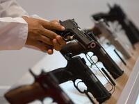 A visitor inspects a pistol gun during the Abu Dhabi International Hunting and Equestrian exhibition (ADIHEX) in the UAE capital Abu Dhabi on August 31, 2019.  KARIM SAHIB / AFP