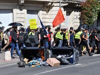 Protesters walk past burning trash bins during an anti-government demonstration called by the "Yellow Vests" (Gilets Jaunes) movement on September 7, 2019 in Montpellier, southern France. Pascal GUYOT / AFP