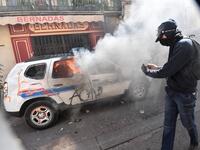 A protester dressed in black takes a picture of a burning French Municipal Police car on the sidelines of an anti-government demonstration called by the "Yellow Vests" (Gilets Jaunes) movement in Montpellier, southern France, on September 7, 2019. Pascal GUYOT / AFP