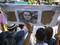 Demonstrators hold up a sign showing the portrait of Hajar Raissouni, a Morrocan journalist of the daily newspaper Akhbar El-Youm, with a caption below in Arabic and English reading "Free Hajar Raissouni" as they gather outside a courthouse holding her trial on charges of abortion in the capital Rabat on September 9, 2019. FADEL SENNA / AFP
