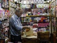 A merchant prepares lunch inside his shop at the Bzourieh market in the centre of the Syrian capital Damascus . The declining value of the pound is a sure sign of Syria's ailing economy. LOUAI BESHARA / AFP
