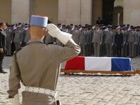French President Emmanuel Macron (L) stands behind the flag-draped coffin of late French President Jacques Chirac during a military tribute at the Invalides (Hotel des Invalides) in Paris on September 30, 2019. Former French President Jacques Chirac died on September 26, 2019 at the age of 86. PHILIPPE WOJAZER / POOL / AFP