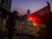 A protester sets fire to the Chinese national flag in the Sha Tin district of Hong Kong on October 1, 2019, as violent demonstrations take place in the streets of the city on the National Day holiday to mark the 70th anniversary of communist China's founding. ISAAC LAWRENCE / AFP