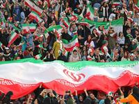 Iranian women cheer and wave their country's national flags as they attend the World Cup Qatar 2022 Group C qualification football match between Iran and Cambodia at the Azadi stadium in the capital Tehran on October 10, 2019. ATTA KENARE / AFP