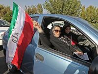Iranian women wave their country's national flag as they arrive at the Azadi stadium in the capital Tehran ahead of the World Cup Qatar 2022 Group C qualification football match between Iran and Cambodia on October 10, 2019.ATTA KENARE / AFP