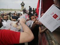 Displaced Syrians receive aid boxes provided by the Turkish Red Crescent on October 19, 2019, in the Syrian border town of of Tal Abyad which was seized by Turkey-backed forces last week. Bakr ALKASEM / AFP