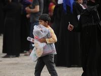 A Syrian girl carries a bag of aid distributed by the Turkish Red Crescent on October 19, 2019, in the Syrian border town of of Tal Abyad seized by Turkey-backed forces last week. Bakr ALKASEM / AFP