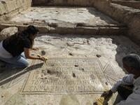 Timnah Goloubin (L), an archaeologist with the Israel Antiquities Authority, shows on October 23, 2019 a mosaic inscription in ancient Greek mentioning a donation received from Emperor Tiberius II, in the Israeli town of Bet Shemesh. The magnificent 1500-year-old church, decorated with spectacular mosaic floors and Greek inscriptions, was discovered during a three-year excavation near a residential area. MENAHEM KAHANA / afp
