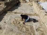 Timnah Goloubin (L), an archaeologist with the Israel Antiquities Authority, shows on October 23, 2019 a mosaic church floor of an Eagle symbol of the Byzantine Empire in the Israeli town of Beit Shemesh. A magnificent 1500-year-old church, decorated with spectacular mosaic floors and Greek inscriptions, was discovered during a three-year excavation near a residential area. MENAHEM KAHANA / afp