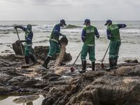 Municipal workers remove spilled crude oil at Pedra do Sal beach in Salvador, Bahia state, Brazil, on October 23, 2019. Large blobs of oil staining more than 130 beaches in northeastern Brazil began appearing in early September and have now turned up along a 2,000km stretch of the Atlantic coastline. The source of the patches remain a mystery despite President Jair Bolsonaro's assertions they came from outside the country and were possibly the work of criminals. ANTONELLO VENERI / AFP
