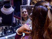 A customer tries on gold jewellery at a store in Amritsar on October 25, 2019. Dhanteras, the first day to mark the Hindu festival of Diwali, is seen as an auspicious day on which to make purchases. NARINDER NANU / AFP