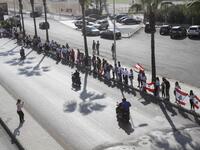 Lebanese protesters hold hands to form a human chain along the coast from north to south as a symbol of unity, during ongoing anti-government demonstrations in the southern Lebanese port city of Sidon on October 27, 2019. Mahmoud ZAYYAT / AFP