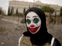 A Lebanese woman with her face painted with the character of the Joker takes part in a protest in downtown Beirut on October 23, 2019 as demonstrations to demand better living conditions and the ouster of a cast of politicians who have monopolised power and influence for decades continue.  Patrick BAZ / AFP