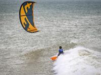 A picture taken on October 10, 2019, shows a kitesurfer riding waves at Dakhla beach in Morocco-administered Western Sahara. In the heart of disputed Western Sahara, a former garrison town has become an unlikely tourist magnet after kitesurfers discovered the windswept desert coast on the Atlantic is perfect for their sport. FADEL SENNA / AFP