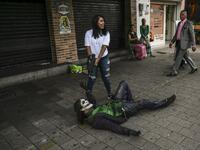 Venezuelan migrant Johnny Tales (R), who makes a living imitating the comicbook and film character "The Joker", poses for a photograph in a street of Medellin, on October 29, 2019. JOAQUIN SARMIENTO / AFP