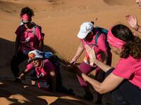 Women encourage each other as they take part in the desert trek "Rose Trip Maroc", on November 4, 2019 in the erg Chebbi near Merzouga. The Rose Trip Maroc is a female-oriented trek where teams of three must travel through the southern Moroccan Sahara desert with a compass, a map and a topographical reporter. JEAN-PHILIPPE KSIAZEK / AFP