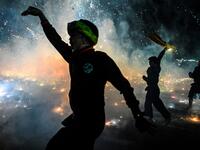 This picture taken on November 5, 2019 shows participants celebrating as fireworks explode after they released a hot-air balloon attached with fireworks during the Tazaungdaing Lighting Festival at Taunggyi in Myanmar's northeastern Shan State. Brightly coloured balloons with hundreds of homemade fireworks woven into their frames are sent soaring into the night sky, showering down cascades of sparks onto adoring crowds in the annual Taunggyi fire balloon festival. Ye Aung THU / AFP