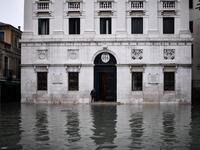 A man stands by the entrance of the Palazzo Patriarcale on the flooded Piazza dei Leoncini square after an exceptional overnight "Alta Acqua" high tide water level, early on November 13, 2019 in Venice. Powerful rainstorms hit Italy on November 12, with the worst affected areas in the south and Venice, where there was widespread flooding. Within a cyclone that threatens the country, exceptional high water were rising in Venice, with the sirocco winds blowing northwards from the Adriatic sea against the lago