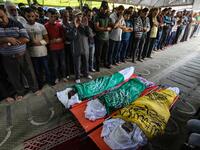 Palestinian mourners pray over the bodies of Rafat Ayad and his two sons Amir and Islam on during a funeral in Gaza City on November 13, 2019. Exchanges of fire triggered by Israel's targeted killing of a top militant in Gaza raged for a second day and showed little sign of easing, with 22 Palestinians killed. Fresh rocket barrages were fired at Israel, which responded with strikes on what it said were Islamic Jihad militant sites and rocket-launching squads in the Gaza Strip.  MAHMUD HAMS / AFP