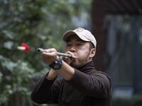 This photo taken on October 23, 2019 shows pet detective Sun Jinrong testing his blowdart as he prepares to search for a missing cat in a residential compound in Beijing. Private sleuth Sun Jinrong brings heat detectors, tiny surveillance cameras, and a blowdart loaded with a tranquiliser to his search for one desperate client's missing loved one: A cat named Duoduo.  NOEL CELIS / AFP