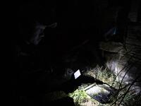 This photo taken on October 23, 2019 shows pet detective Sun Jinrong using a night vision camera as he searches for a missing cat in a residential compound in Beijing. Private sleuth Sun Jinrong brings heat detectors, tiny surveillance cameras, and a blowdart loaded with a tranquiliser to his search for one desperate client's missing loved one: A cat named Duoduo.  NOEL CELIS / AFP