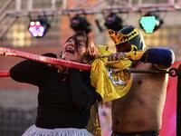 Bolivian wrestler Blanca Perez (L), aka "Katy The Beautiful", a member of the Fighting Cholitas, fights with a male wrestler at Sharks of the Ring wrestling club in El Alto, Bolivia, on November 24, 2019. After a fortnight hiatus due to anti-government protests and blockades, the Fighting Cholitas are back in the ring. The unrest was triggered by the disputed October 20 election, which Evo Morales claimed to have won and opposition groups said was rigged. Ronaldo SCHEMIDT / AFP