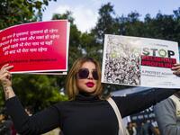 A protester displays placards during a demonstration against the Indian government's Citizenship Amendment Bill in New Delhi on December 14, 2019. Protests against a divisive new citizenship law raged on December 14 as Washington and London issued travel warnings for northeast India following days of violent clashes that have killed two people so far. Jewel SAMAD / AFP